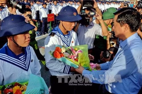 Bí thư Thành ủy Đinh La Thăng tặng hoa chúc mừng và động viên các thanh niên trúng tuyển NVQS tại điểm giao quân Quận 9, Thành phố Hồ Chí Minh. Ảnh: Thế Anh - TTXVN