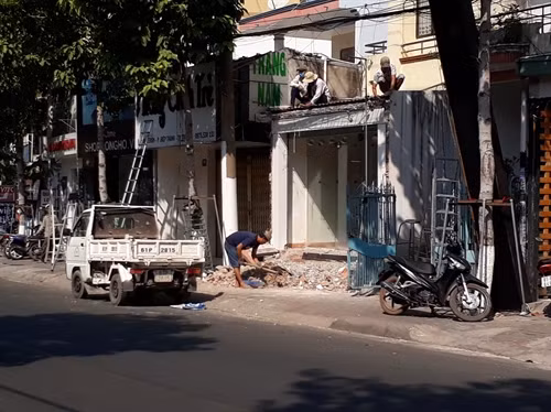 Người dân tự tháo dỡ những công trình vi phạm lấn chiếm vỉa hè. Ảnh: Huyền Trang - TTXVN