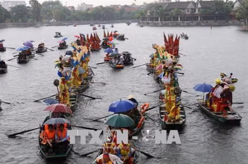 Lễ rước thuyền rồng trên sông Ngô Đồng. Ảnh: Ninh Đức Phương - TTXVN