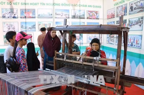 Du khách tham quan dệt thổ cẩm của đồng bào An Giang. Ảnh: Công Mạo-TTXVN