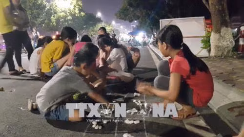 Trải nghiệm trò chơi dân gian tại phố đi bộ Trịnh Công Sơn. Ảnh: Đinh Thuận - TTXVN