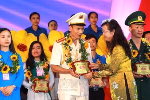 Đồng chí Nguyễn Thị Quyết Tâm, Chủ tịch Hội đồng Nhân dân Thành phố Hồ Chí Minh trao tặng biểu trưng cho Thanh niên tiêu biểu làm theo lời Bác toàn quốc lần thứ V - năm 2018. Ảnh: Thanh Vũ-TTXVN