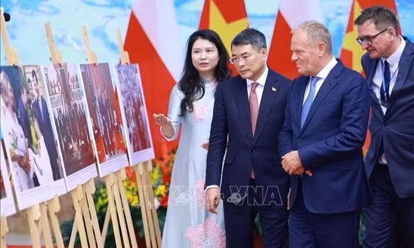 Thủ tướng Lê Minh Hưng và Thủ tướng Ba Lan xem trưng bày ảnh về quan hệ hai nước