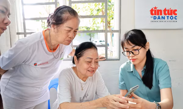 Cán bộ phường hướng dẫn người dân thao tác các dịch vụ công trên điện thoại. Ảnh: Lưu Niệm