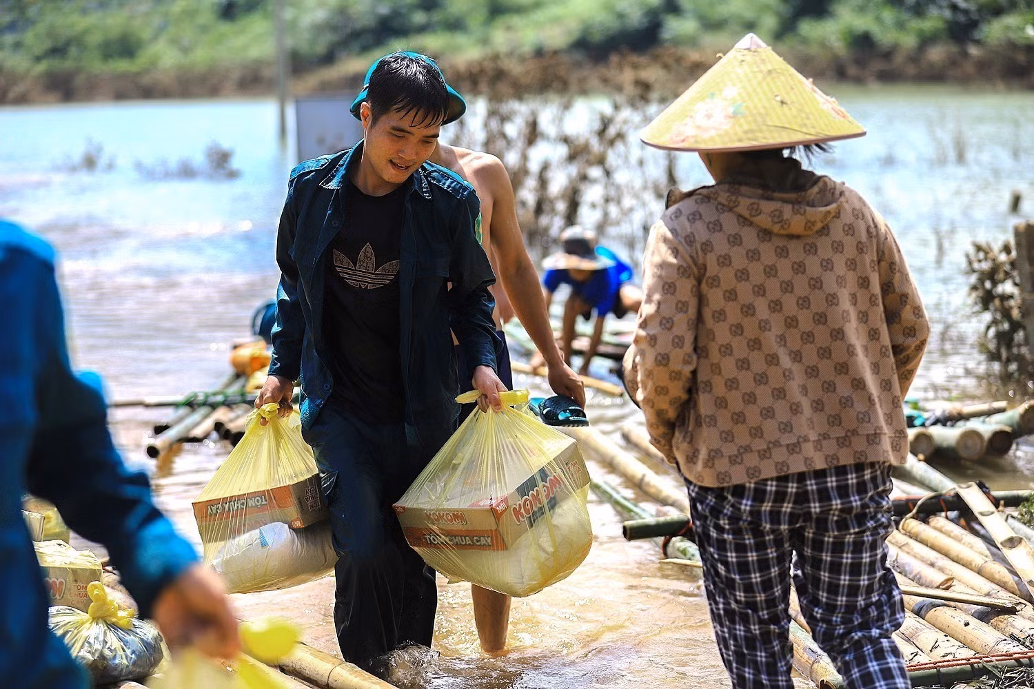 Lực lượng dân quân thôn Thỏi Láo và cán bộ xã Mường Hoa vận chuyển lương thực, nhu yếu phẩm tiếp tế cho các hộ dân bị cô lập.