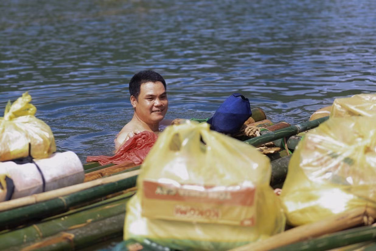 Vận chuyển lương thực tiếp tế cho 18 hộ dân thôn Thỏi Láo bị cô lập do đường ngập sâu trong nước, có đoạn ngập hơn 2m nước.