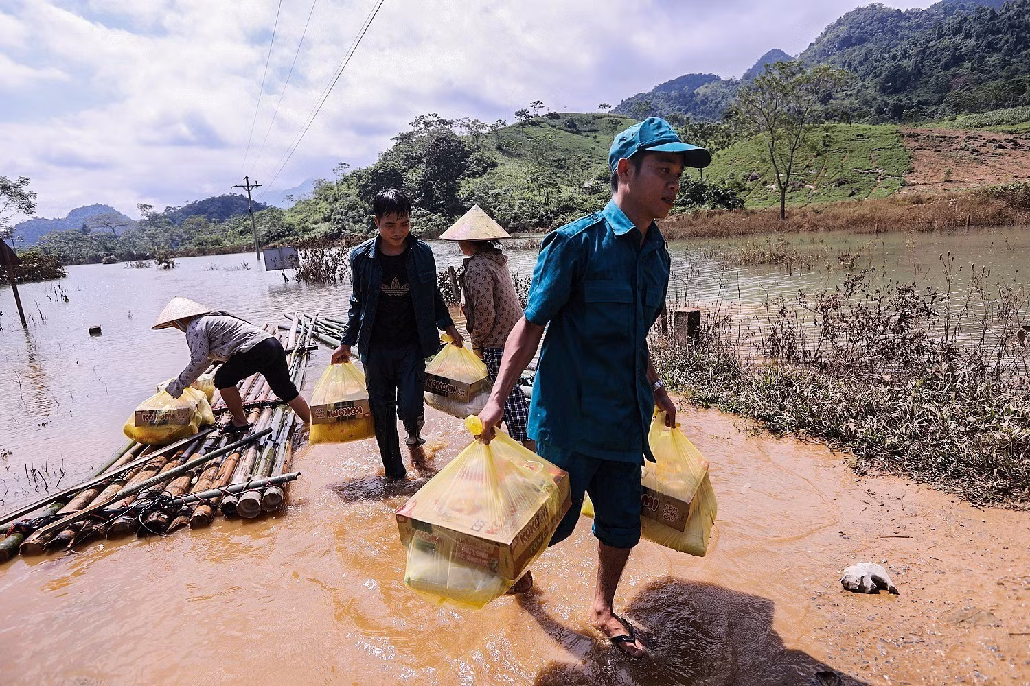 Lực lượng dân quân thôn Thỏi Láo và cán bộ xã Mường Hoa vận chuyển lương thực, nhu yếu phẩm tiếp tế cho các hộ dân bị cô lập.