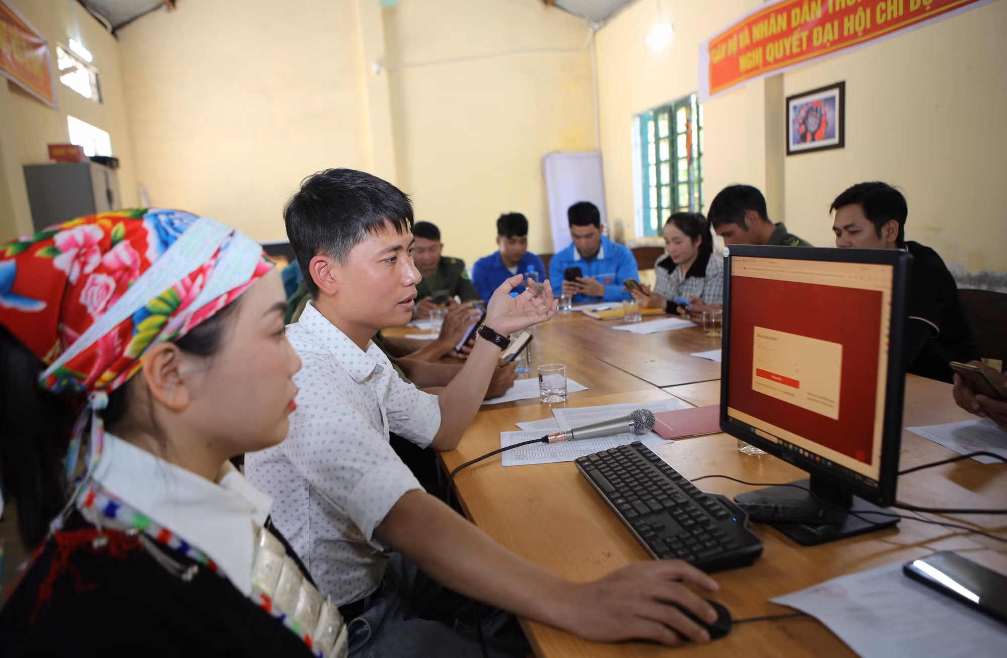 Hướng dẫn người dân thôn Sơn Hà, xã Bát Xát thực hiện nộp hồ sơ trực tuyến trên cổng dịch vụ công. Ảnh: TTXVN phát