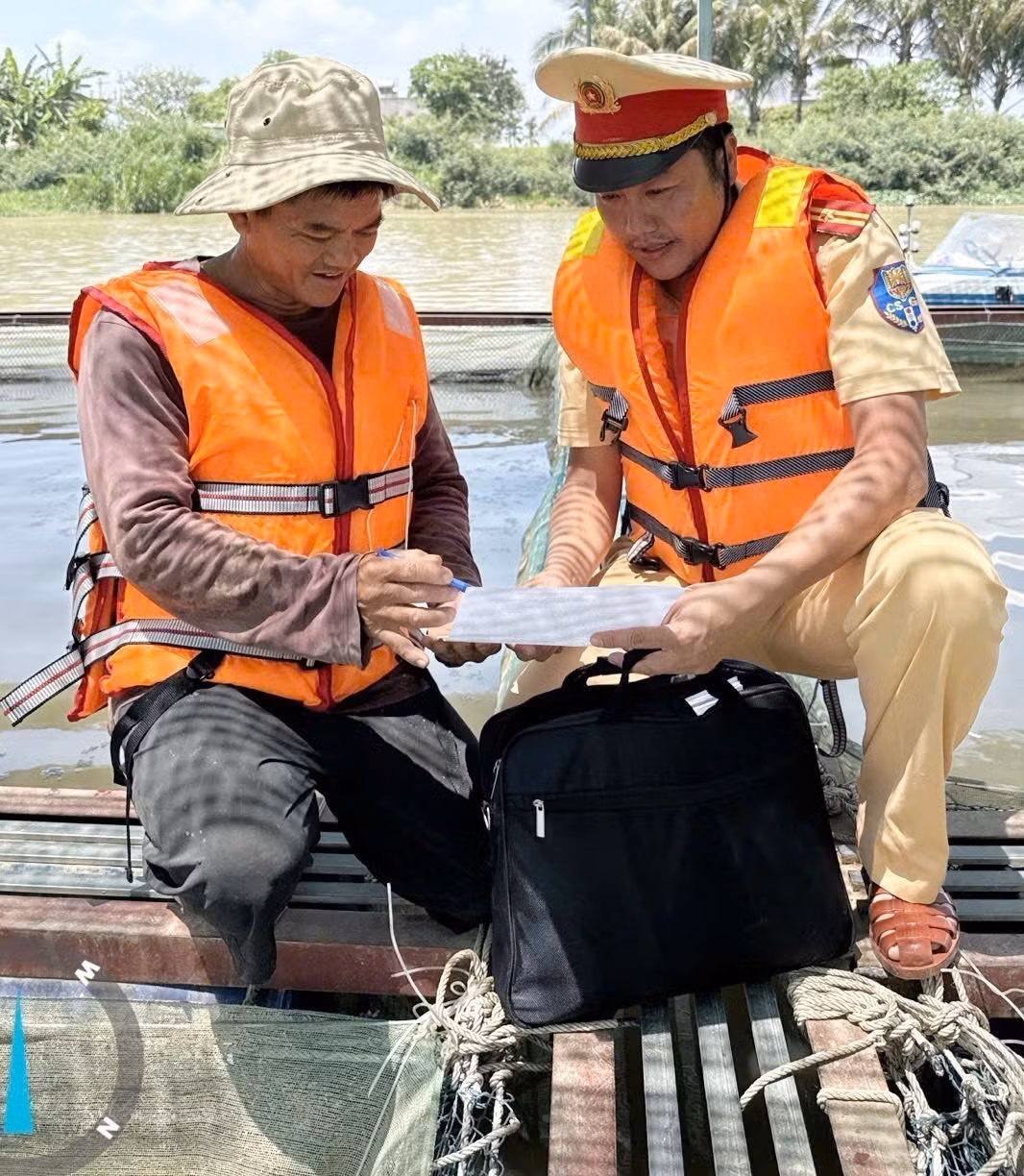 Lực lượng Cảnh sát đường thủy số 1, Cảnh sát giao thông Công an tỉnh Đắk Lắk phát tờ rơi tuyên truyền Luật giao thông đường thủy nội địa. Ảnh: TTXVN phát