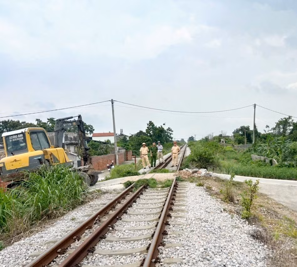 Lực lượng CSGT Công an tỉnh phối hợp với chính quyền địa phương và các đơn vị xóa bỏ các điểm đi qua đường tàu tự phát ở Đông Triều. Ảnh: TTXVN phát