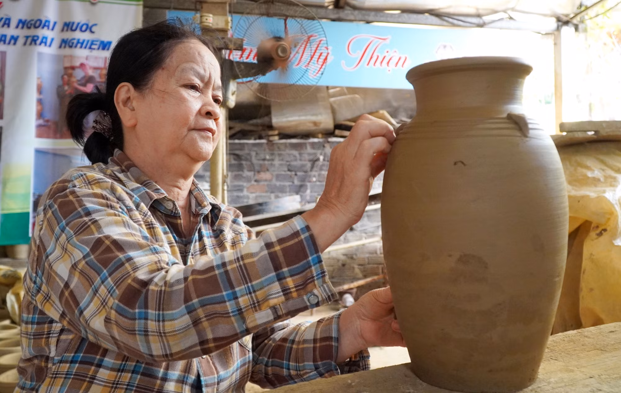 Nghệ nhân tạo hình sản phẩm gốm truyền thống từ nguyên liệu đất sét.