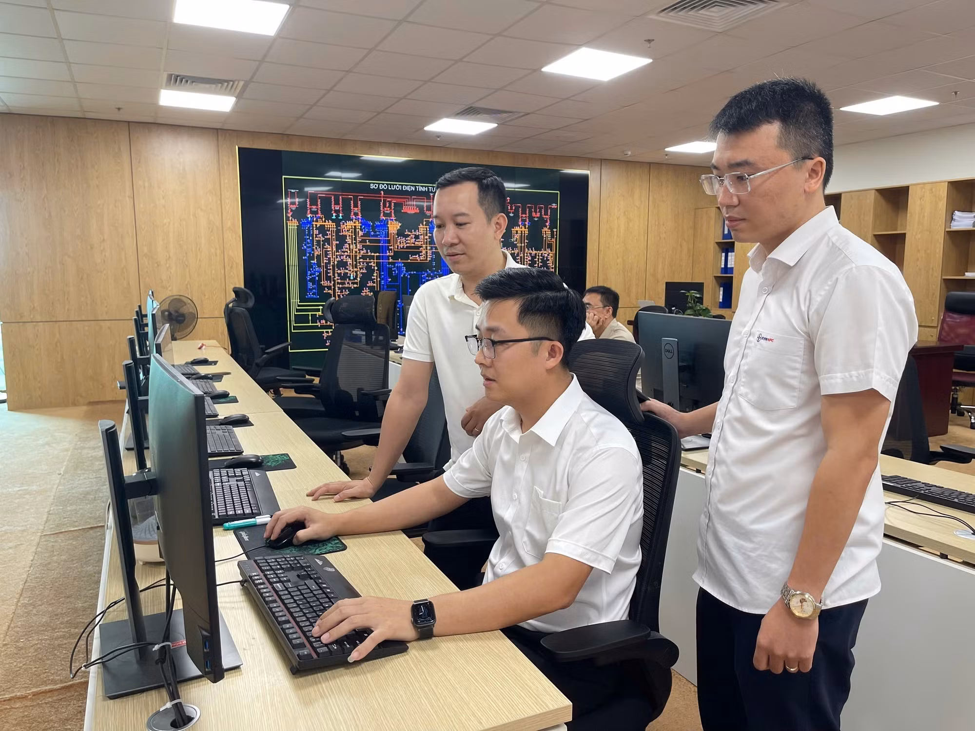Kỹ sư Phạm Quang Tiến (ngồi giữa) cùng các đồng nghiệp đã đưa ra nhiều sáng kiến, giải pháp áp dụng tự động hóa quy trình làm việc.