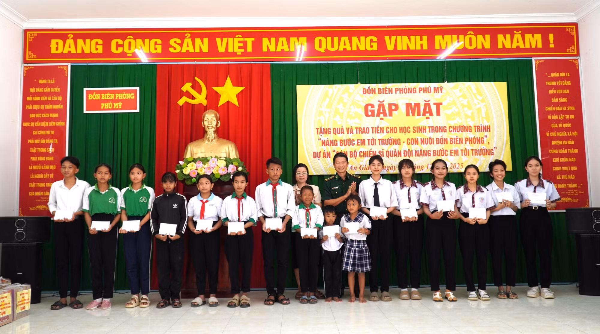 Trung tá Bùi Thanh Ngàn, Đồn trưởng Đồn Biên phòng Phú Mỹ trao quà cho các học sinh thuộc dự án “Cán bộ chiến sĩ Quân đội nâng bước em đến trường”.