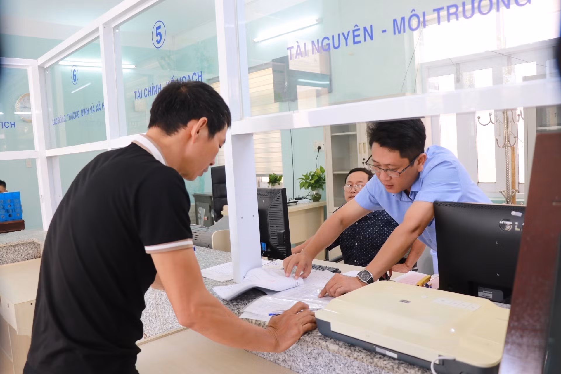 Cán bộ, công chức tại Trung tâm hành chính công xã Khánh Vĩnh hướng dẫn người dân làm thủ tục hành chính liên quan đến lĩnh vực tài nguyên môi trường. Ảnh: Phan Sáu/TTXVN