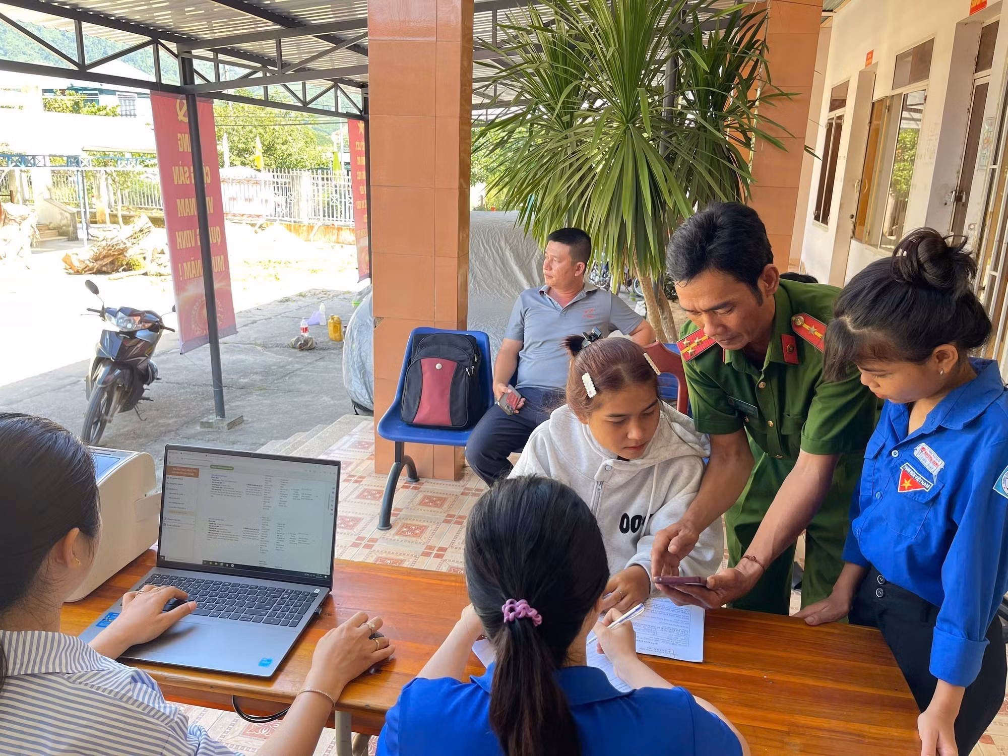 Cán bộ công chức, lực lượng thanh niên hỗ trợ người dân Trung Khánh Vĩnh làm hồ sơ tại điểm tiếp nhận ở cơ sở. Ảnh: TTXVN phát