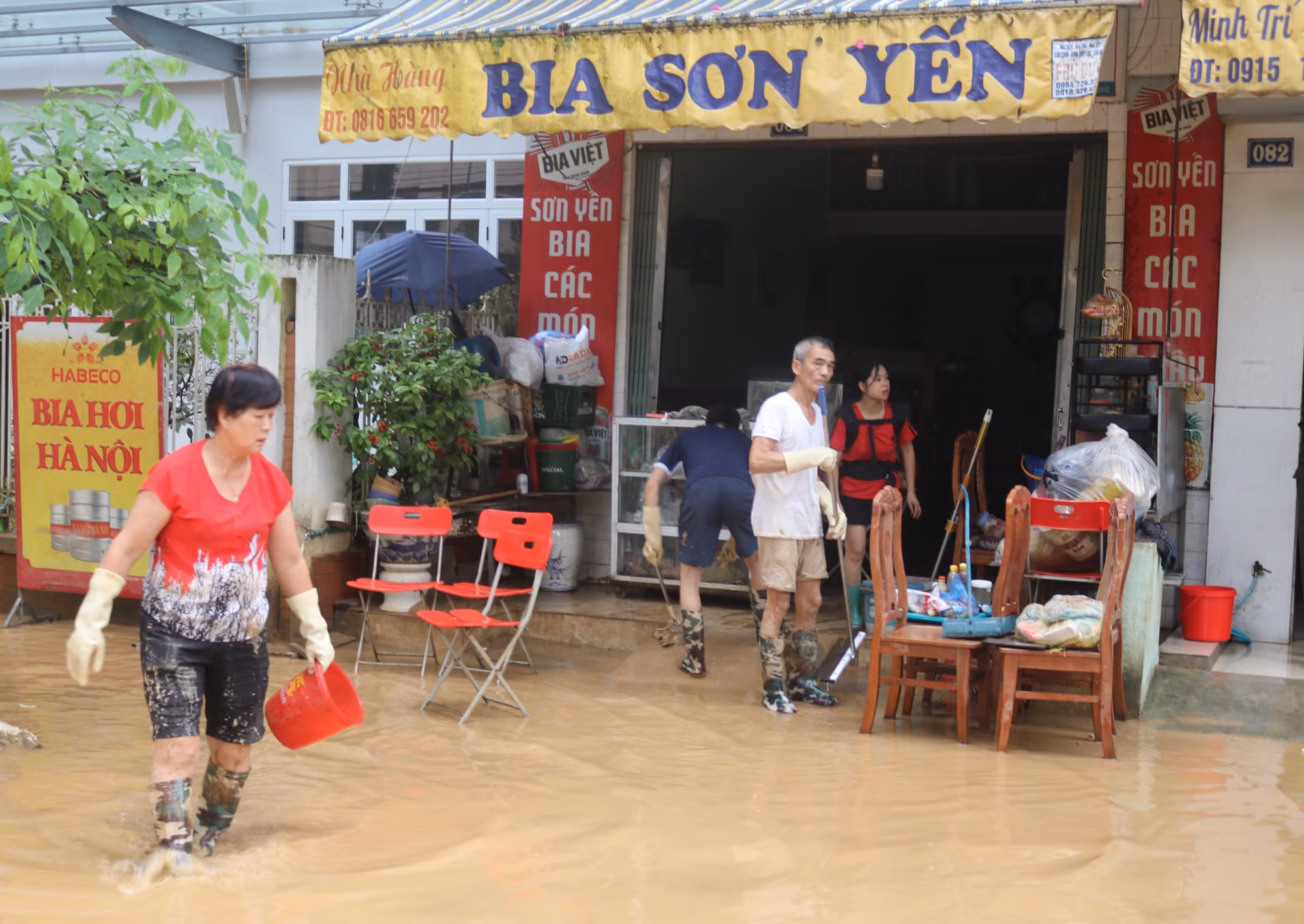 Người dân dọn dẹp bùn đất vào nhà do ngập lụt. Ảnh: Chu Hiệu/TTXVN