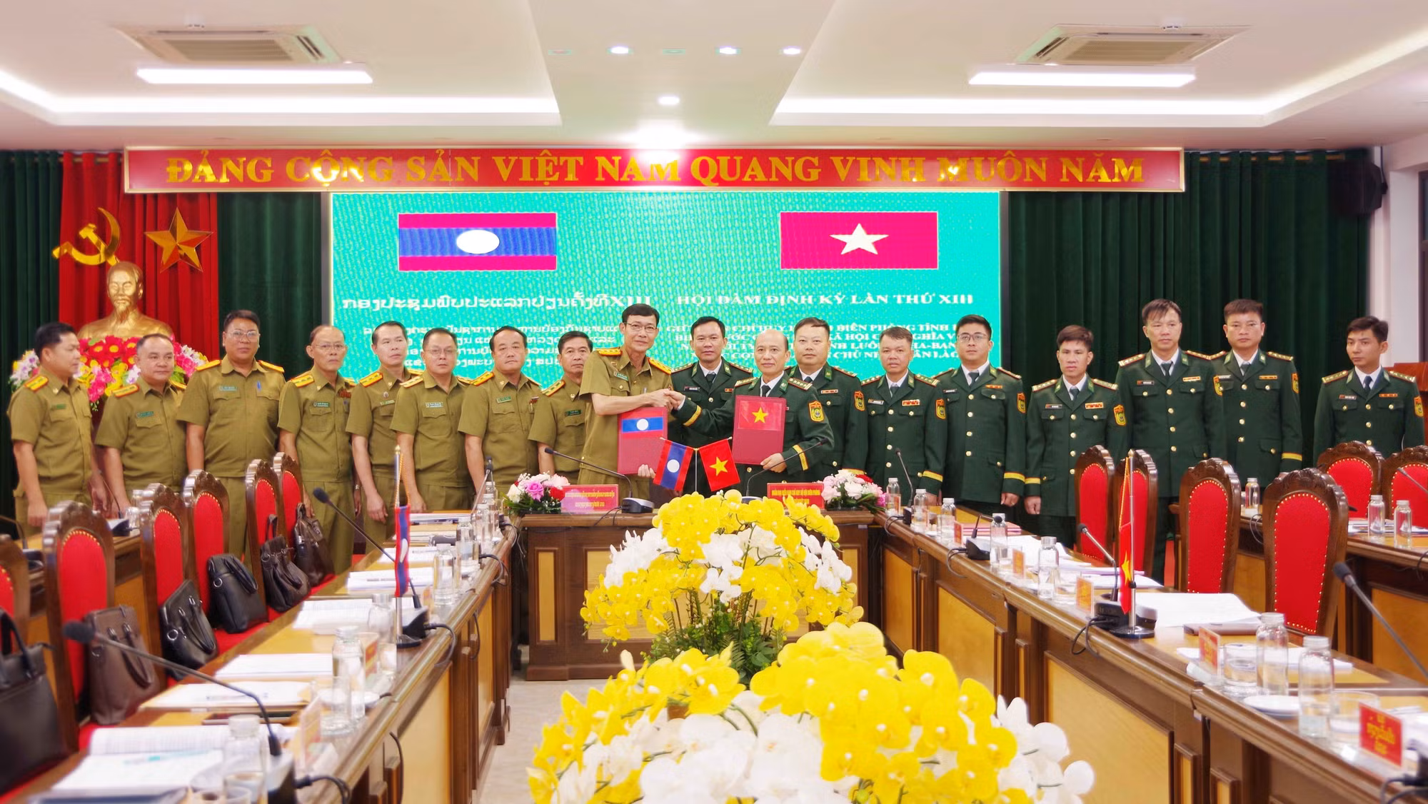 Đại tá Vừ A Khua, Phó Chỉ huy trưởng Ban Chỉ huy BĐBP tỉnh Điện Biên và Đại tá Pạ Sợt Phổn Mạ Lắt, Phó Giám đốc Ty An ninh tỉnh Luông Pha Bang trao biên bản ghi nhớ hội đàm. Ảnh: TTXVN phát