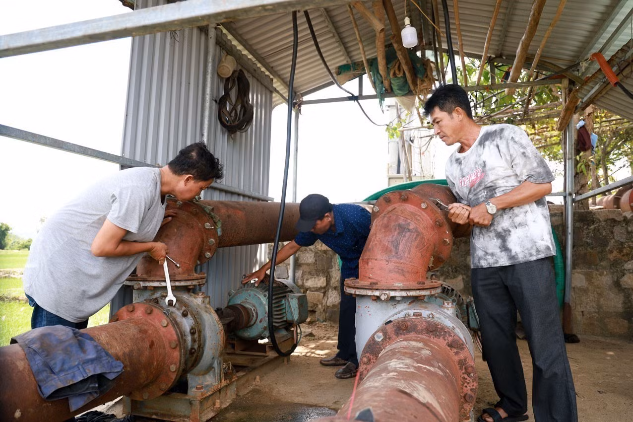 Công nhân Trạm thủy nông kênh chính Bắc Đồng Cam, tỉnh Đắk Lắk lắp đặt máy bơm để chống hạn.