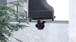 Nghệ sĩ treo ngược người chơi piano từ độ cao 40 m