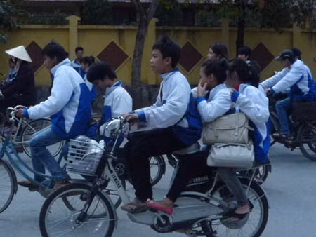 Học sinh đi xe đạp điện quên...mũ ảnh 1
