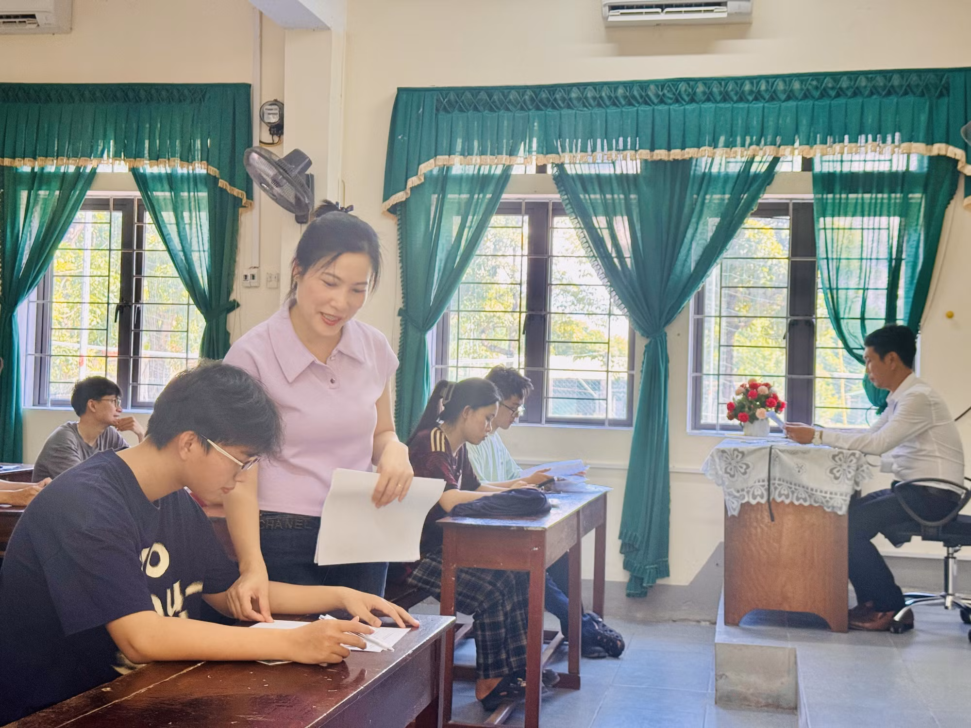 Giáo viên tại điểm thi Trường THPT Chuyên Hà Tĩnh hướng dẫn thí sinh đối chiếu thông tin cá nhân, đính chính sai sót (nếu có).