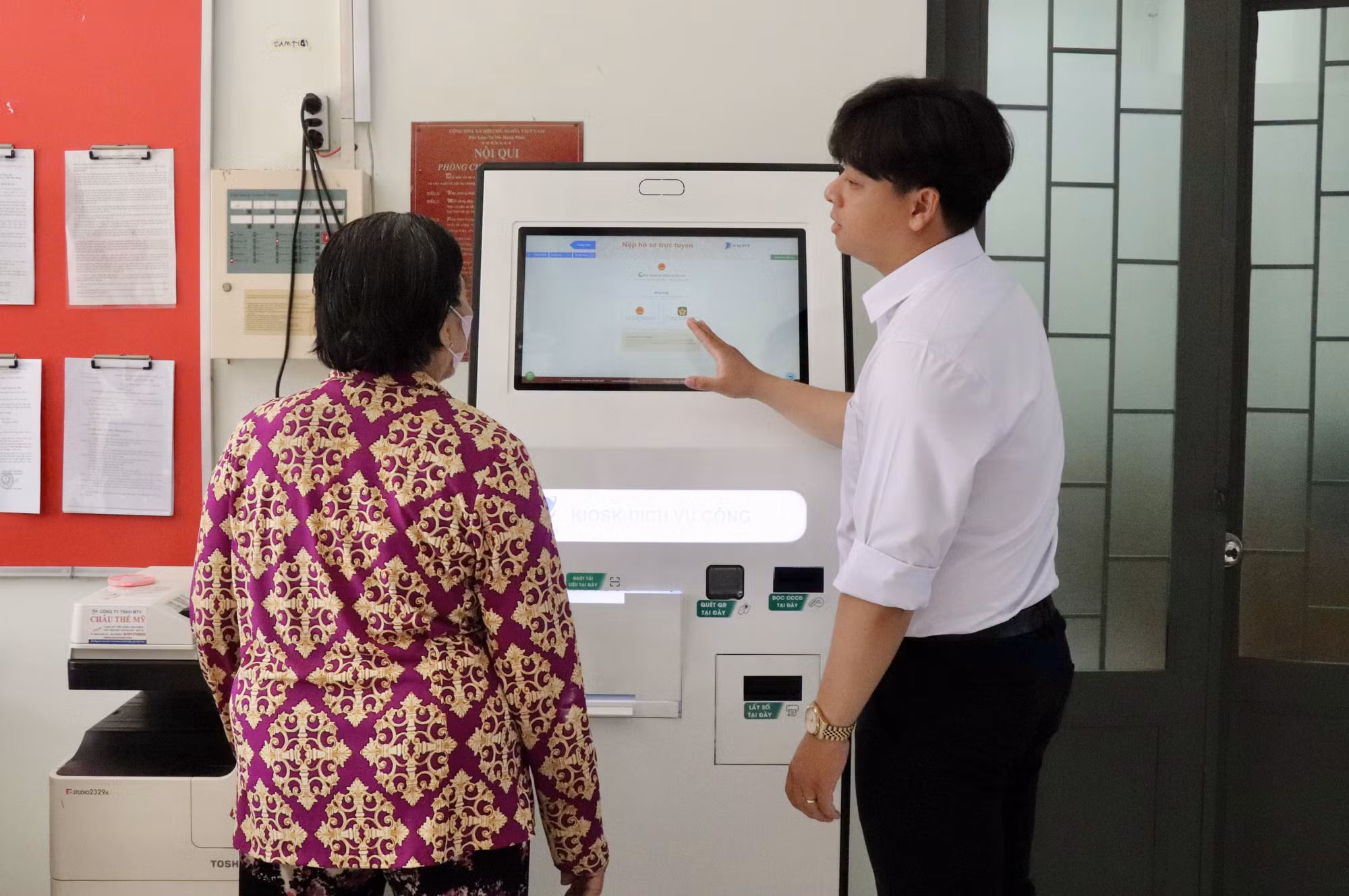 Cán bộ xã Mỹ Hoà Hưng, tỉnh An Giang hướng dẫn người dân nộp hồ sơ trực tuyến.