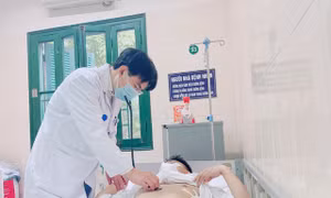 PGS-TS Phùng Duy Hồng Sơn thăm khám cho một bệnh nhân trẻ tuổi đang điều trị lóc động mạch chủ. Ảnh: thanhnien.vn