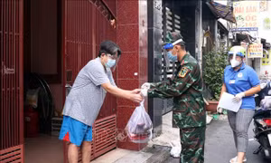 Cán bộ, chiên sỹ Sư đoàn 309 vận chuyển quà tặng nhu yếu phẩm sinh hoạt đến cho người dân tại phường 6, quận Tân Bình. Ảnh: Xuân Khu-TTXVN