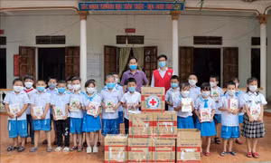 Ông Phạm Xuân Thạch, Phó Chủ tịch Hội Chữ thập đỏ Nghệ An trao một số thiết bị học tập cho học sinh Trường tiểu học Phú Thành, xã Phú Thành, huyện Yên Thành. Ảnh: Văn Tý-TTXVN
