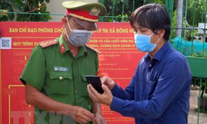 Quét QR để khai báo y tế tại chốt kiểm soát. Ảnh: Xuân Triệu-TTXVN