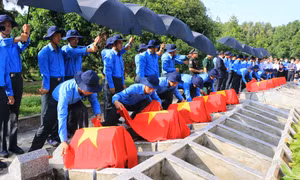 Đội K91 thực hiện nghi thức an táng hài cốt các liệt sỹ. Ảnh: Nhựt An – TTXVN