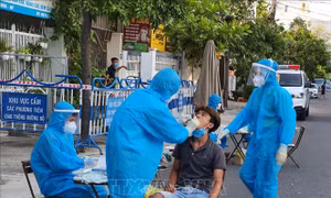 Cán bộ y tế của Trung tâm Kiểm soát Bệnh tật tỉnh Khánh Hòa lấy mẫu xét nghiệm PCR trong khu phong tỏa tạm thời trên địa bàn thành phố Nha Trang. Ảnh: TTXVN 