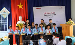 Trao quà cho các e học sinh Trường Phổ thông dân tộc bán trú cấp 1,2 Măng Bút II. Ảnh: Cao Nguyên - TTXVN