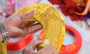 Công đoạn vẽ, trang trí hoạ tiết cho khăn xếp là công đoạn đòi hỏi sự tỉ mỉ, khéo tay từ người thợ. Ảnh: Công Luật-TTXVN