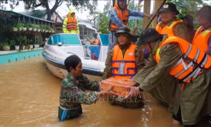 Lực lượng công an tỉnh Thừa Thiên - Huế trao tặng mì tôm cho các gia đình vùng trũng. Ảnh: TTXVN phát