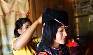 Các thiếu nữ dân tộc Hà Nhì chuẩn bị trang phục đi chơi tết. Ảnh: Phan Tuấn Anh - TTXVN