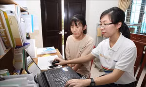 Nguyễn Thị Thu Hằng (áo trắng) tìm hiểu các kiến thức trên mạng. Ảnh: Hải Yến-TTXVN.