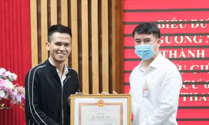 Ông Nguyễn Xuân Lưu, Bí thư Quận uỷ, Chủ tịch UBND quận Thanh Xuân tặng Giấy khen biểu dương tài xế xe tải Nguyễn Ngọc Mạnh (31 tuổi, quê ở huyện Đông Anh) chiều 1/3. Ảnh: Doãn Tấn - TTXVN