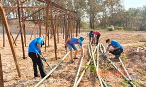 Đoàn viên thanh niên xã Lộc Tấn (huyện Lộc Ninh) hỗ trợ xây dựng chuồng trại nuôi nhốt gia súc cho người dân. Ảnh: bptv.vn