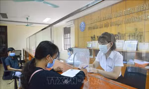 Cán bộ Bảo hiểm xã hội huyện Mường Chà hướng dẫn người dân kê khai đăng ký ứng dụng VssID. Ảnh: Xuân Tư – TTXVN