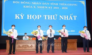 Chủ tịch Hội đồng nhân dân tỉnh Tiền Giang khóa X, nhiệm kỳ 2021 – 2026 Võ Văn Bình tặng hoa chúc mừng lãnh đạo Ủy ban nhân dân tỉnh Tiền Giang tiếp tục trúng cử. Ảnh: Hữu Chí - TTXVN
