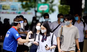 Xịt khử khuẩn cho thí sinh sau khi thi tại điểm thi trường trung học cơ sở Collete (Quận 3, Thành phố Hồ Chí Minh). Ảnh: Thành Chung - TTXVN