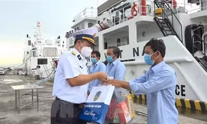 Đại tá Vũ Duy Lưu, Phó Chủ nhiệm Chính trị Vùng 2 Hải quân thăm hỏi, động viên, tặng quà ngư dân. Ảnh: TTXVN phát