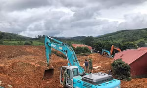 Phương tiện cơ giới đào bới tìm kiếm người bị vùi lấp. Ảnh: TTXVN phát