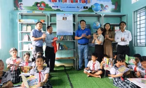 Ban tổ chức, Lãnh đạo địa phương và Ban giám hiệu Trường Tiểu học Ba Dinh khai trương Tủ sách. Ảnh: Đinh Hương - TTXVN