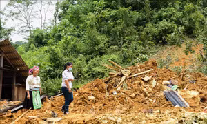 Người dân hỗ trợ gia đình nạn nhân thu dọn vụ sạt lở. Ảnh: Nam Sương - TTXVN