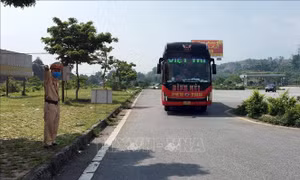 Lực lượng chức năng điều tiết các phương tiện vào chốt kiếm dịch y tế tại trạm thu phí Km 237. Ảnh : Quốc Khánh - TTXVN