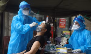 Nhân viên y tế quận Hoàn Kiếm lấy mẫu xét nghiệm COVID-19 cho các trường hợp có nguy cơ cao trong khu vực liên quan đến ca dương tính với SARS-CoV-2 tại phố Hàng Mắm (phường Lý Thái Tổ) ngày 18/7/2021. Ảnh: Minh Quyết - TTXVN
