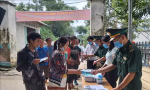 Người dân xã Xín Cái thực hiện rửa tay sát khuẩn và nhận khẩu trang trước khi vào nghe tuyên truyền phổ biến pháp luật về xuất, nhập cảnh. Ảnh: Nguyễn Chiến - TTXVN
