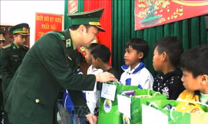 Cán bộ Bộ Tư lệnh Bộ đội Biên phòng tặng quà học sinh "Con nuôi Đồn Biên phòng" tại khu vực biên giới Quảng Bình. Ảnh: Võ Dung -TTXVN